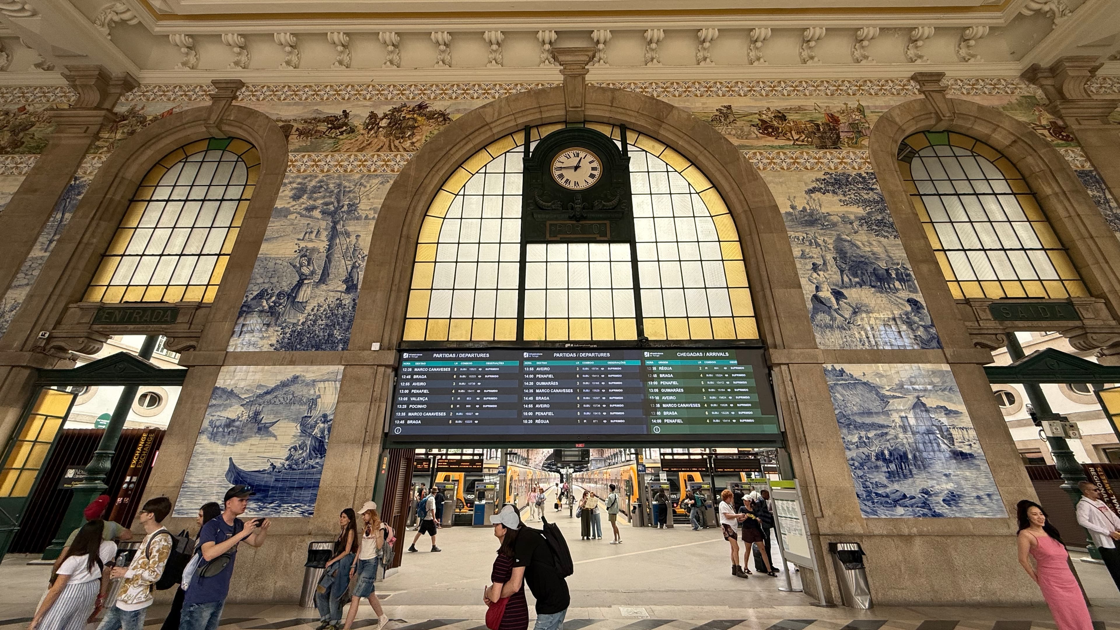 The grand entrance hall of São Bento station, decorated with massive, detailed tile murals.